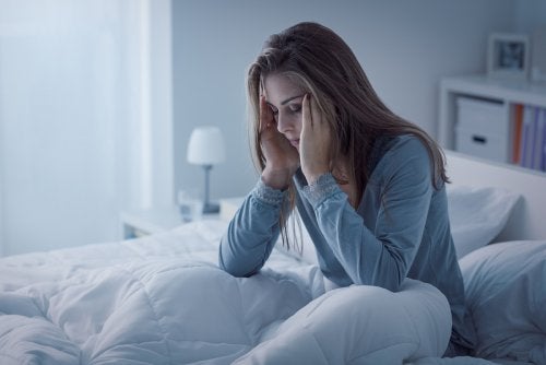 Mujer en la cama con insomnio por estrés 