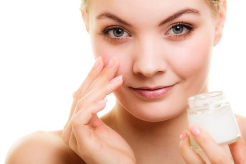mujer aplicando crema antiarrugas en el rostro
