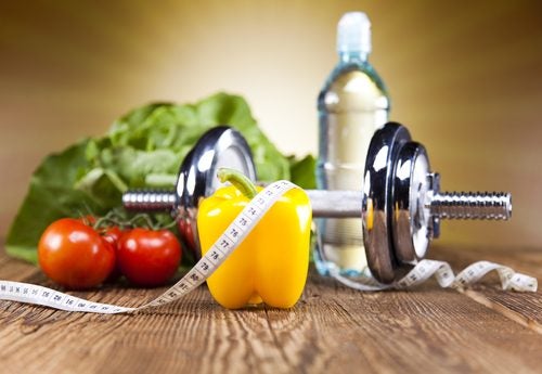 Alimentos saludables, una pesa y una cinta mÃ©trica
