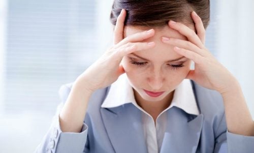 mujer con las manos en la cabeza que sufre preocupación crónica