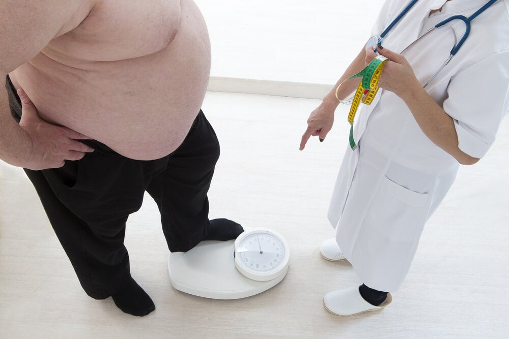 Hombre con obesidad pesándose.