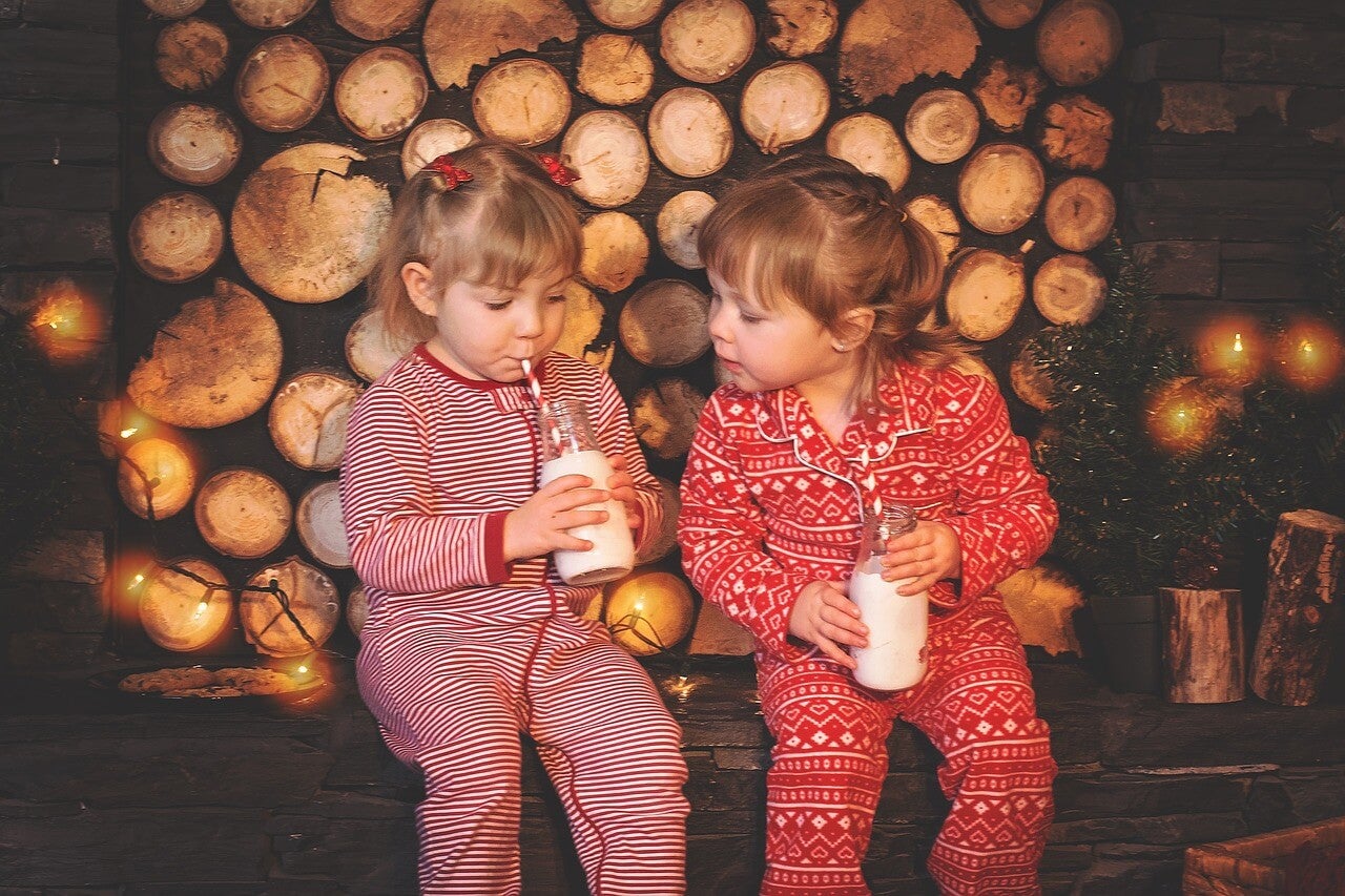 Dos niñas en pijama bebiendo leche.