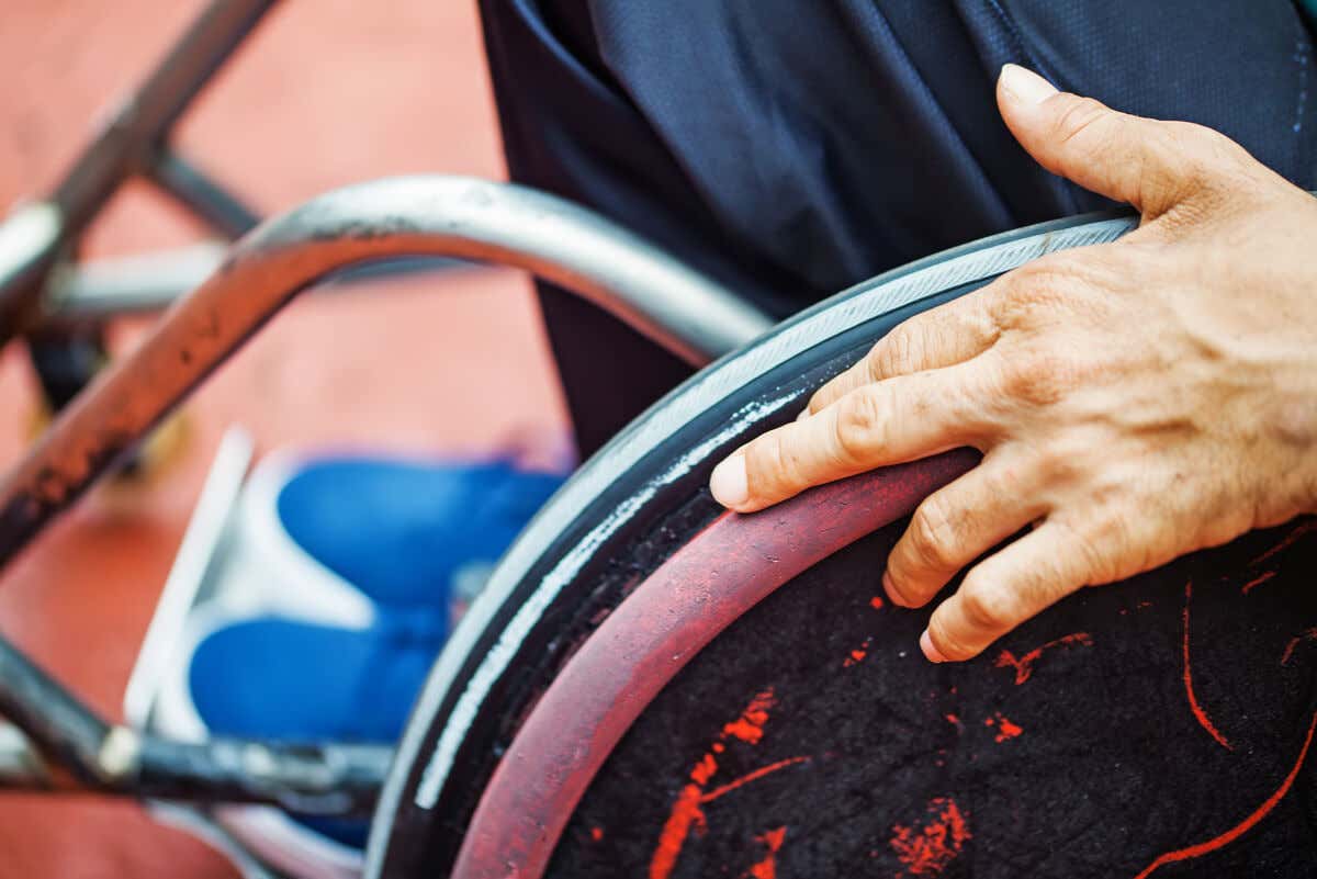 Pessoa em cadeira de rodas devido à poliomielite.