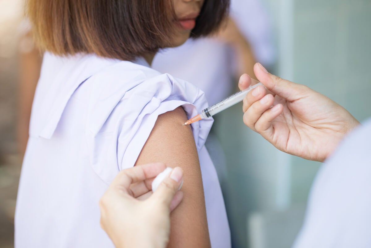 Menina sendo vacinada no braço.